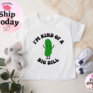 May include: White baby onesie with a green pickle cartoon character and the text "I'm kind of a big dill".