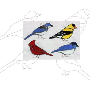 May include: Four stained glass bird ornaments, each with a different color and design. The birds are a blue jay, a cardinal, a yellow finch, and a bluebird.