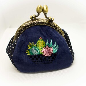 Neceser pequeño, compacto pero al mismo tiempo muy espacioso. Cartera de mano. Un cierre de metal, con punto de cruz el cactus.