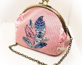 Small, compact but at the same time very capacious cosmetics bag. Clutch wallet. A metal clasp, with cross-stitch feathers.