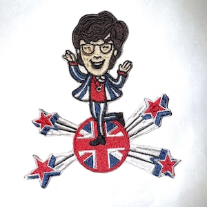 May include: Embroidered patch featuring a cartoon character with brown hair, glasses, and a red and blue striped suit. The character stands on a red circle with a Union Jack design, surrounded by starbursts with red and blue stars.