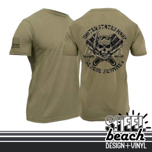 Puede incluir: Camiseta verde oliva con un gráfico negro en la espalda que presenta una calavera con una máscara de buceo, las palabras "United States Navy" y "Rescue Swimmer". La manga izquierda tiene una pequeña bandera estadounidense.