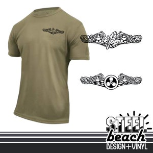 May include: Olive green short-sleeve t-shirt with a small black graphic on the chest. Two black and white graphic designs are displayed to the right. The bottom right corner features the text "STEEL beach DESIGN + VINYL".