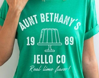 May include: Green t-shirt with white text that reads "Aunt Bethany's Jello Co. Real lime flavor!" and a graphic of a lime jello mold on a plate. The text also includes the numbers "19" and "89".