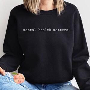 K&ouml;nnte beinhalten: Ein schwarzer Pullover mit dem Text "mental health matters" in wei&szlig;en Buchstaben.