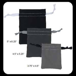 May include: Three small, rectangular drawstring bags in varying shades of gray. The bags are made of a soft fabric and have a silver accent near the top. The sizes are 5" x 6.25", 4.5" x 5.25", and 3.75" x 4.5". Each bag has a ribbon drawstring.