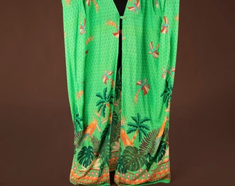 May include: A long, green, flowing robe with a tropical print featuring palm trees, birds, and other foliage. The robe has a V-neck and a button closure.
