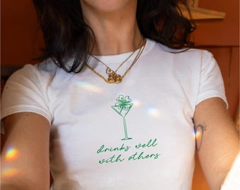 Drinks Well With Others Women's Baby Tee, Cute Funny St Patrick's Day T-Shirt, 90s Y2K Trendy, Fitted St. Paddy's Tee, Shamrock