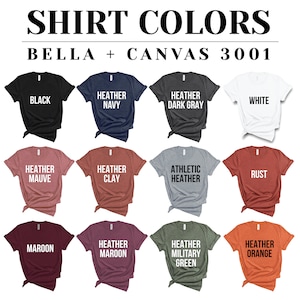May include: A display of Bella + Canvas 3001 t-shirts in various colors, including black, navy, dark gray, and white. Other colors include heather mauve, clay, athletic heather, rust, maroon, heather maroon, military green, and heather orange. The text "SHIRT COLORS" is at the top.