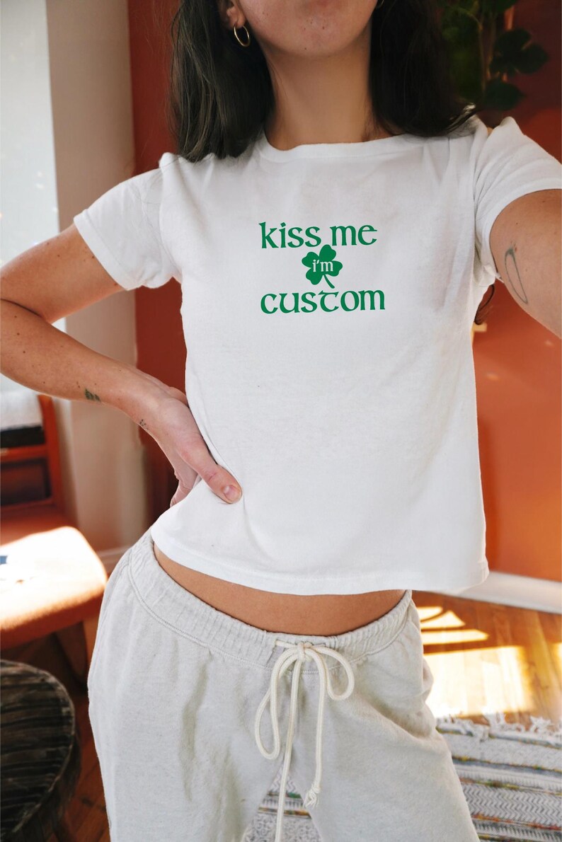 May include: White t-shirt with a green shamrock and the text "kiss me i'm custom".