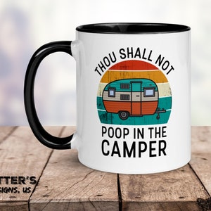 Pode incluir: Caneca de café de cerâmica branca com borda e alça pretas. A caneca apresenta uma ilustração retrô de uma caravana com o texto "Thou Shall Not Poop in the Camper".