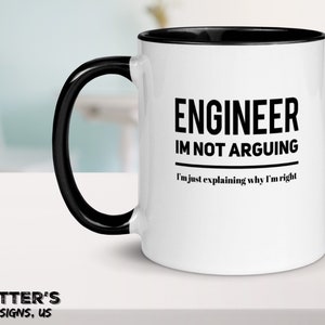 Op de afbeelding: Witte keramische koffiemok met een zwarte rand en handvat. De mok heeft zwarte tekst met de tekst "ENGINEER IM NOT ARGUING I'm just explaining why I'm right".