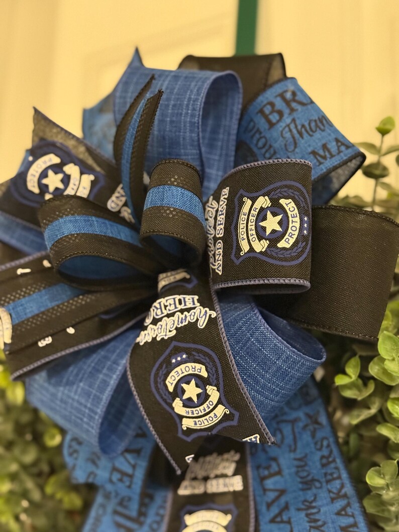 May include: Blue and black ribbon with a police officer badge design. The ribbon has the text "Protect and Serve" and "Thank you Makers".