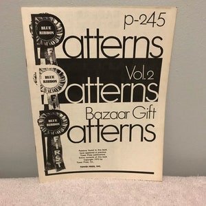 May include: A vintage book titled "Bazaar Gift Patterns Vol. 2" with a blue ribbon design on the cover. The book is from Tower Press, Inc. and was published in 1970.