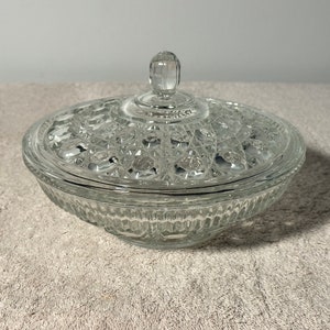 May include: A clear glass candy dish with a lid. The dish has a diamond pattern and the lid has a knob on top.