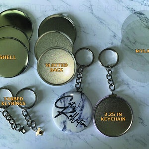 May include: An assortment of keychain components, including shells, slotted backs, tabbed keyrings, and mylar circles. A finished 2.25-inch keychain with a marble design and the text "Cat's Kollection" is also shown.