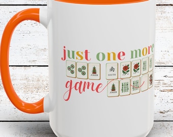 May include: White ceramic mug with an orange interior and handle. The mug features the text "just one more game" with colorful Mahjong tile illustrations. A fun gift for game lovers.