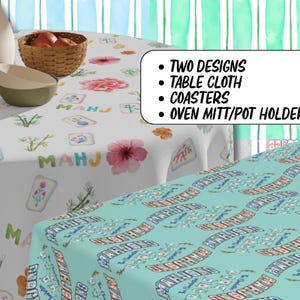 May include: Two tablecloth designs are shown, one white with floral and tile patterns, the other turquoise with text. The image also shows coasters and oven mitts/pot holders. The text on the image says "Two Designs, Table Cloth, Coasters, Oven Mitt/Pot Holder."