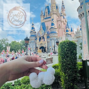 May include: White fluffy Mickey Mouse ears with a pink castle in the background.