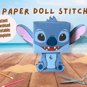 Puede incluir: Una muñeca de papel azul del personaje Stitch, con grandes orejas y una expresión amigable. La imagen incluye el texto "Paper Doll Stitch" y "Instant Download Printable Template". También se ven tijeras, pegamento y lápices de colores.