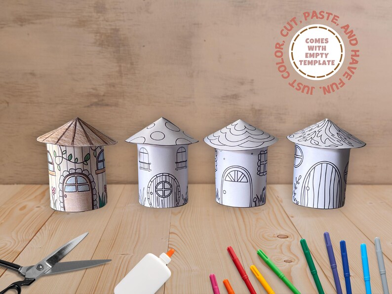 May include: Four printable paper houses with different designs, ready to be colored, cut, and pasted. The houses are arranged in a row on a wooden surface. The image also includes scissors, glue, and colored markers.