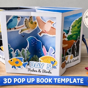 May include: A 3D pop-up book template featuring illustrations of birds, fish, and deer. The book has a white frame with blue and white accents. The text "DAY 5 Fishes & Birds" and "DAY 6 Apple & Animals" is visible. A banner at the bottom reads "3D POP UP BOOK TEMPLATE".