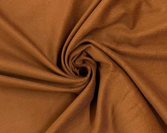 May include: A close-up of a brown corduroy fabric. The fabric is soft and has a subtle texture.