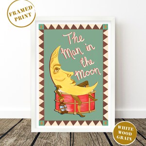 May include: A framed print featuring a whimsical illustration of the Man in the Moon. The artwork depicts a yellow crescent moon with a face, lounging on a red drum, holding a lantern. The text "The Man in the Moon" is written in pink script against a teal background.