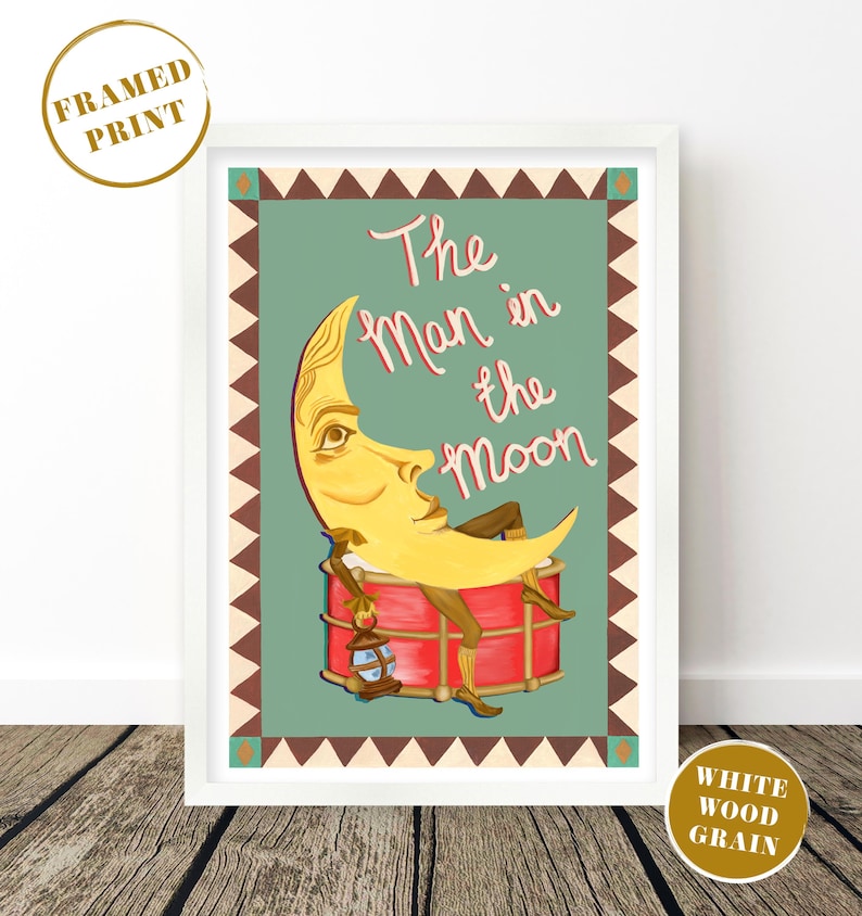 May include: A framed print featuring a whimsical illustration of the Man in the Moon. The artwork depicts a yellow crescent moon with a face, lounging on a red drum, holding a lantern. The text "The Man in the Moon" is written in pink script against a teal background.