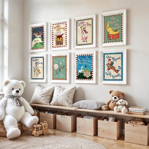 May include: A collection of framed nursery rhyme illustrations, including "Mother Goose" and "The Man in the Moon," adorn a white wall. A large white teddy bear sits near a wooden bench with storage boxes. The room is decorated with soft toys and pillows.