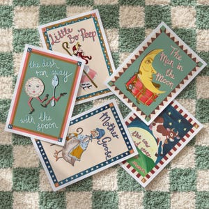 May include: A collection of five illustrated nursery rhyme art prints. Each print features a different scene, including "Little Bo Peep," "The Dish Ran Away with the Spoon," and "The Man in the Moon." The prints have a vintage aesthetic with colorful illustrations.