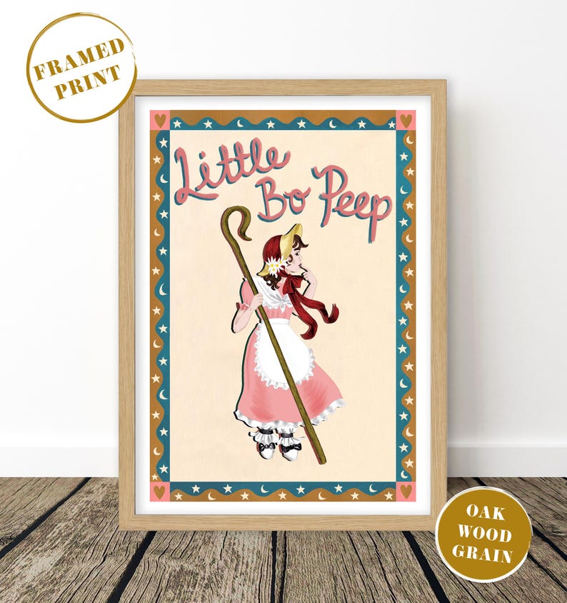May include: Framed print featuring a whimsical illustration of Little Bo Peep in a pink dress, holding a shepherd's crook. The artwork has a vintage aesthetic, with a light beige background and a decorative border of stars and moons. The frame is oak wood grain.