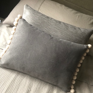 Gorgeous handmade velvet pom pom cushions. Can be made in a colour combination to suit your choice eg grey, pink, navy, white, mustard