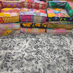 Puede incluir: Tres pequeños sillones patchwork apilados. Cada silla tiene un asiento cuadrado y respaldos y reposabrazos bajos. El diseño patchwork utiliza varias telas en rosa, amarillo y azul. Las sillas están sobre una alfombra estampada con un diseño floral gris y blanco.