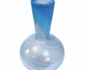 May include: A blue and white glass vase with a swirling pattern. The vase has a round base and a narrow neck.