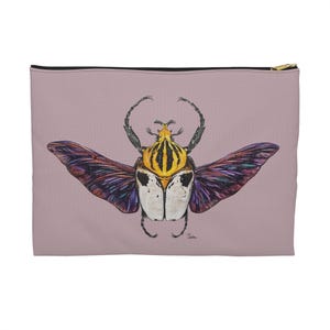 Puede incluir: Un escarabajo morado e iridiscente con rayas amarillas y negras en la espalda y alas blancas. El escarabajo está sobre un fondo rosa claro.