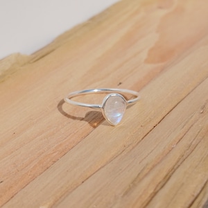 May include: A silver ring with a pear-shaped moonstone.