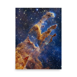 May include: A print depicting the Pillars of Creation, a nebula within the Eagle Nebula. The image features towering formations of gas and dust in hues of gold, brown, and red, set against a backdrop of a starry blue sky. This celestial artwork is a striking display of cosmic beauty.
