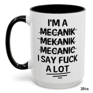May include: White ceramic mug with a black interior and handle. The mug features the text "I'M A MECANIK MEKANIK MECANIC I SAY FUCK A LOT" in black, with the word "MECANIK" crossed out. The mug is 15oz.