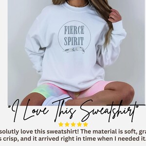 a woman wearing a white sweatshirt and pink shorts