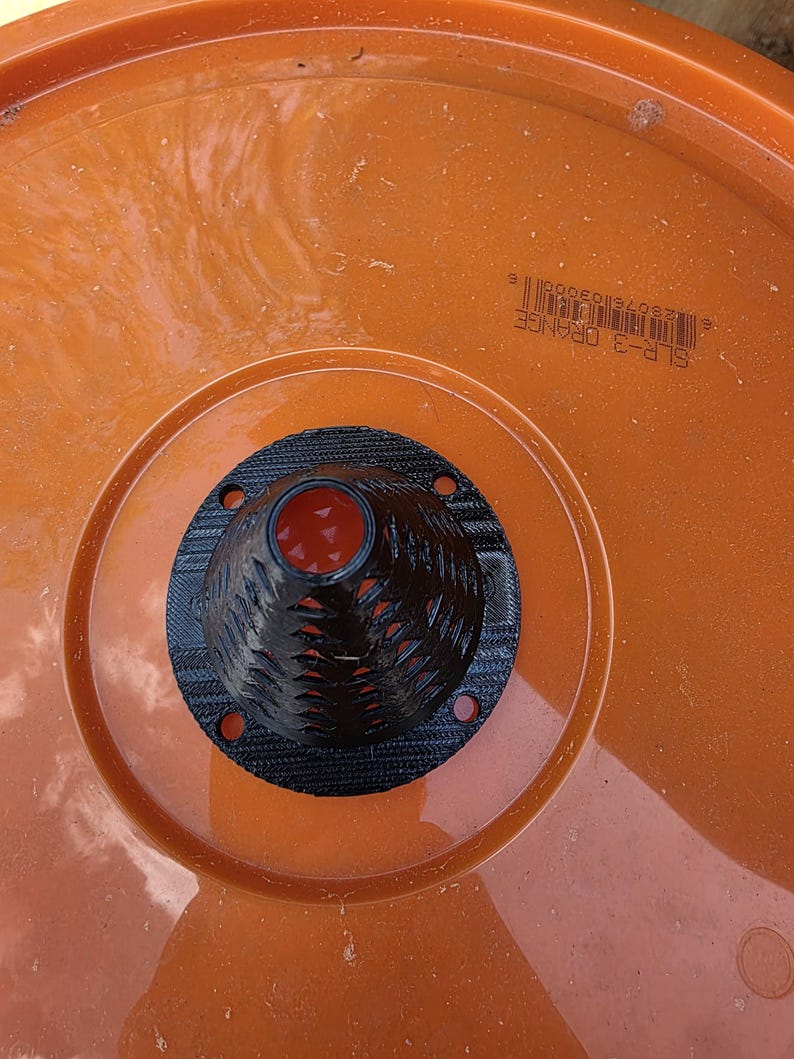 Fly trap bucket placed outdoors near barn