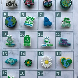 May include: A chart with 20 colorful shoe charms with different environmental themes. The charms feature images like a heart, a turtle, a flower, a lightbulb, and a tree. The text on the charms includes phrases like "Save Our Earth", "Love Your Mother", "Save the Turtles", and "Plant a Tree".