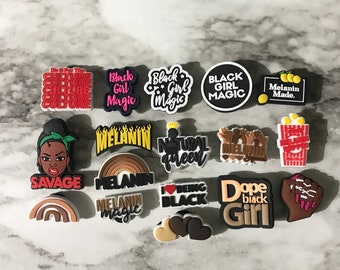 May include: A collection of 15 colorful shoe charms with various phrases and designs related to Black culture, including "Black Girl Magic", "Melanin", "Natural Queen", "Dope Black Girl", and "Do It For The Culture".