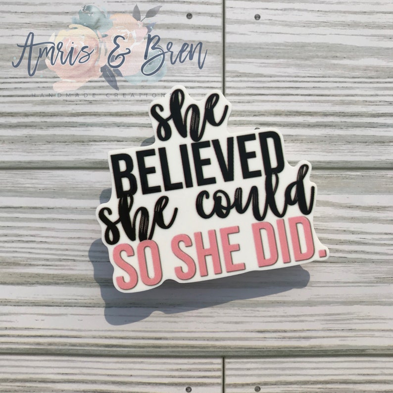 May include: White vinyl sticker with pink and black lettering. The sticker reads "She believed she could so she did."