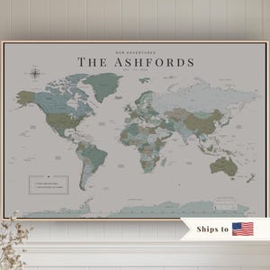 May include: A rectangular wall map featuring a world map in muted green, blue, and grey tones. The text reads OUR ADVENTURES, THE ASHFORDS, EST. 2023, PAST ADVENTURES, and ADVENTURES TO COME. A compass rose is in the top left corner and a legend is included.