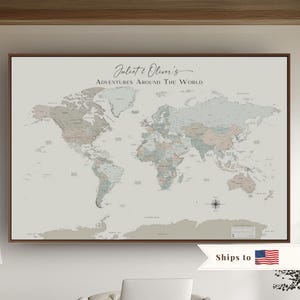 May include: A rectangular framed world map print with a light gray background and muted pastel-colored continents. The text at the top reads Juliet & Oliver's Adventures Around The World. A compass rose is located in the lower right corner.