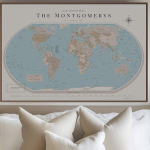 Peut inclure: Une carte murale encadrée présentant un océan bleu sourd et des terres beiges. Le texte indique OUR ADVENTURES THE MONTGOMERYS EST 2023. Elle comprend une rose des vents, une légende et une échelle. La carte est dans un cadre brun fin.