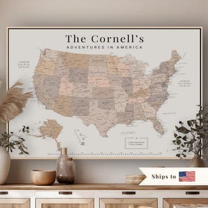 May include: A framed wall map of the United States in muted beige and brown tones, featuring the text 'The Cornell's ADVENTURES IN AMERICA' at the top. The map includes state outlines, city names, and a legend box labeled Past Adventures and Yet to Explore.