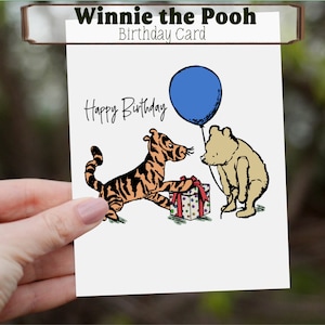 May include: A birthday card featuring Winnie the Pooh characters. The card has the text "Winnie the Pooh Birthday Card" at the top and "Happy Birthday" in the center. Tigger is shown with a gift, and Pooh holds a blue balloon.