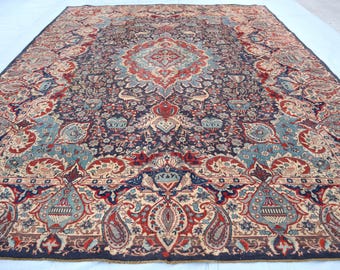 May include: A vintage Persian rug with a navy blue background and intricate floral patterns in shades of red, cream, and blue.